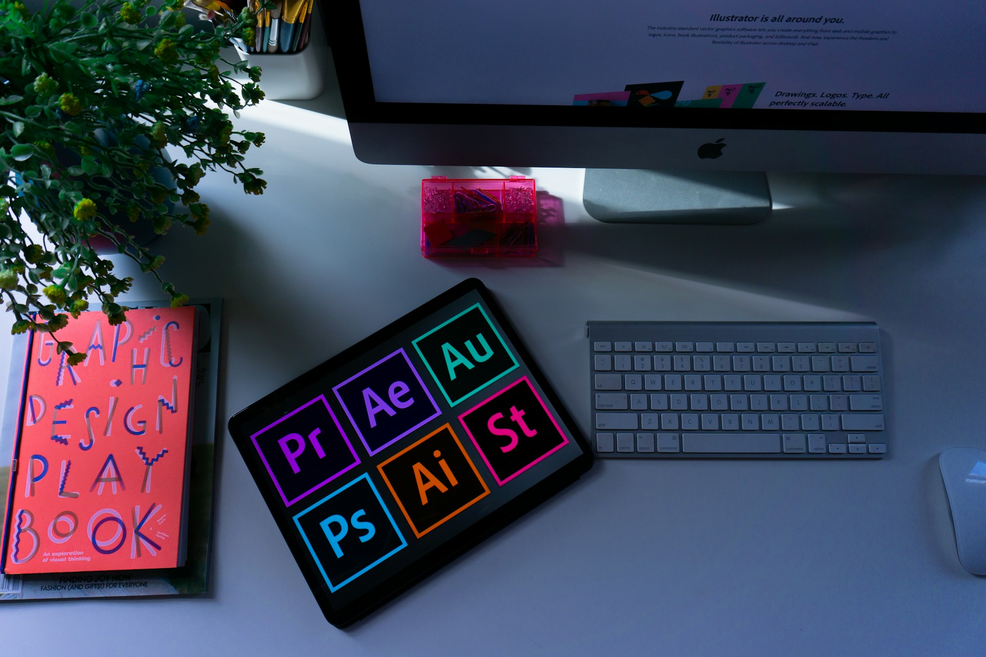 Foto van een grafische werkplek met een mac computer en een ipad.